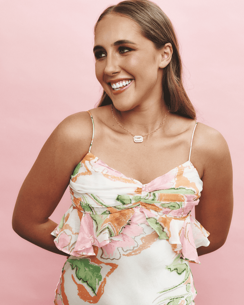 Woman wearing a floral dress against a pink background
